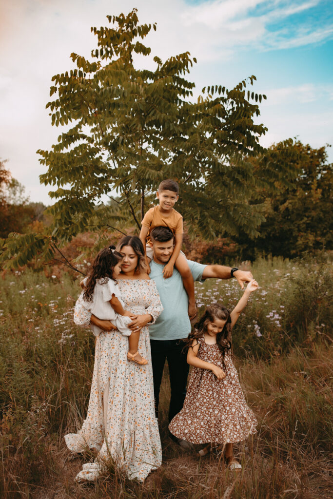 Family of 5 dancing in an Oak Creek, WI field at sunset. 
